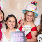 Guests posing for photos at Jennifer's 50th birthday celebration with a photo booth at San Antonio Marriott Northwest in San Antonio, Texas.